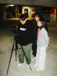three people standing in a parking garage